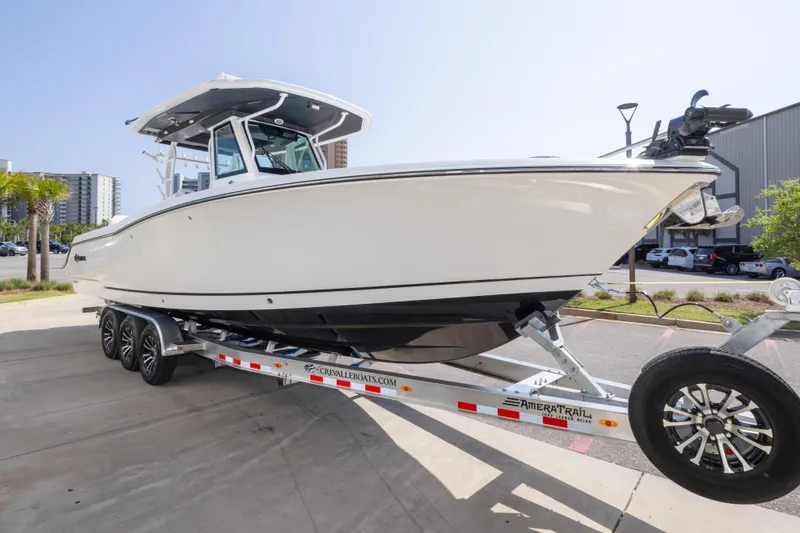Slide: The Image of 2026 Crevalle 33 CSF boat on trailer, parked outdoors, showcasing sleek design. - 17