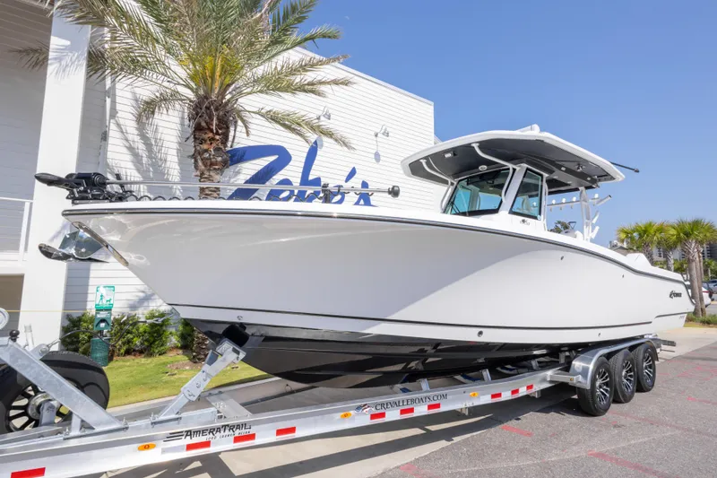 Slide: The Image of 2026 Crevalle 33 CSF boat on trailer, parked outdoors near palm trees. - 2
