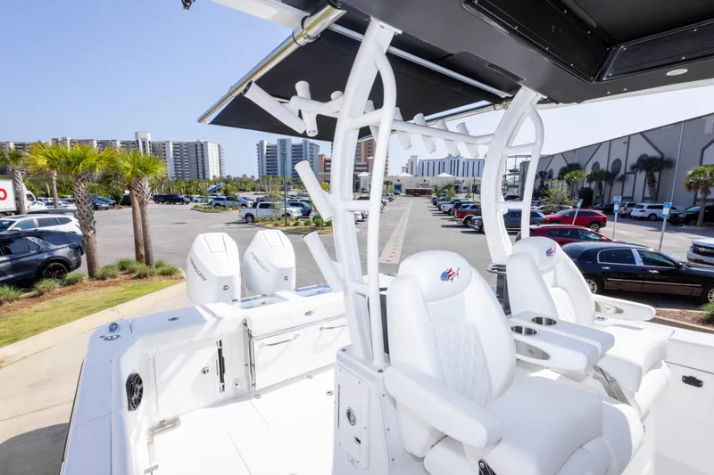 Slide: The Image of 2026 Crevalle 33 CSF boat with white seating and Mercury engines in a marina setting. - 43