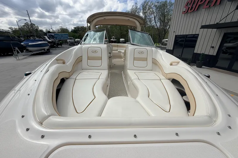 Slide: The Image of 2002 Sea Ray 290 Bowrider with spacious seating and sleek design at a marina. - 12