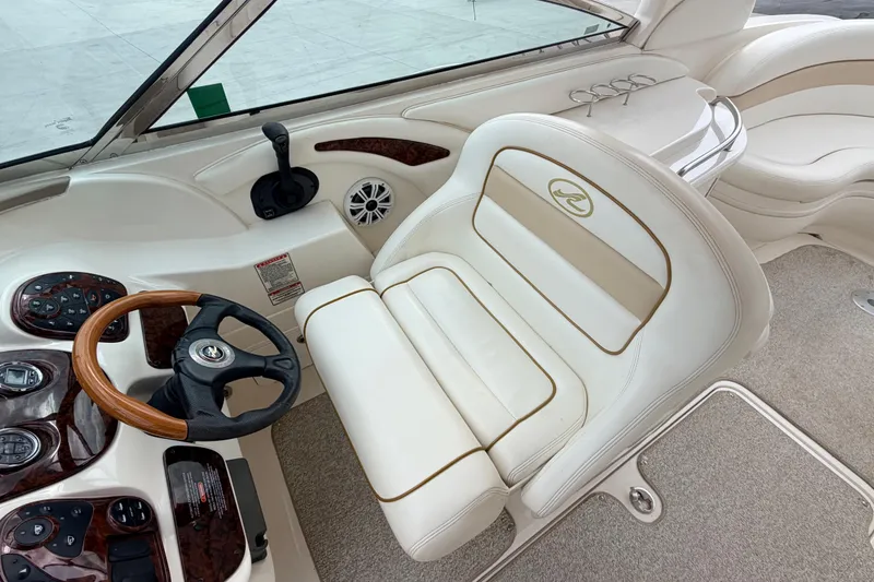 Slide: The Image of 2002 Sea Ray 290 Bowrider cockpit with steering wheel and plush seating. - 15