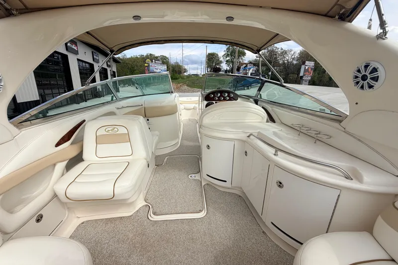 Slide: The Image of 2002 Sea Ray 290 Bowrider interior with beige seating and dashboard view. - 16