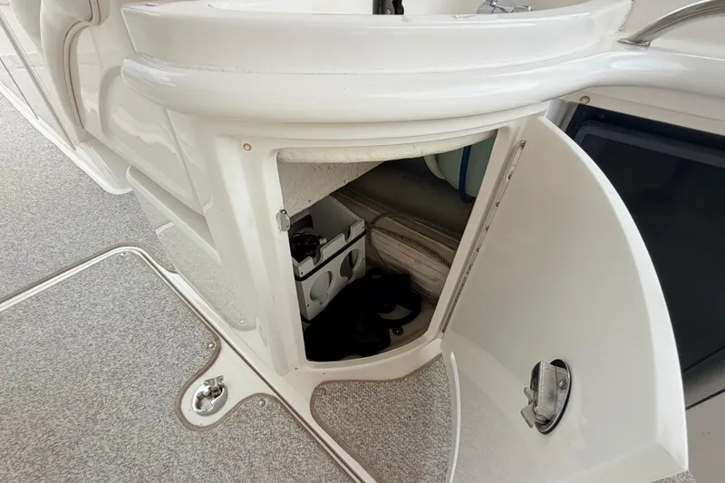 Slide: The Image of Open storage compartment on 2002 Sea Ray 290 Bowrider boat, showing interior contents. - 20