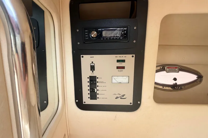 Slide: The Image of Control panel inside 2002 Sea Ray 290 Bowrider boat, featuring electrical switches and stereo system. - 24