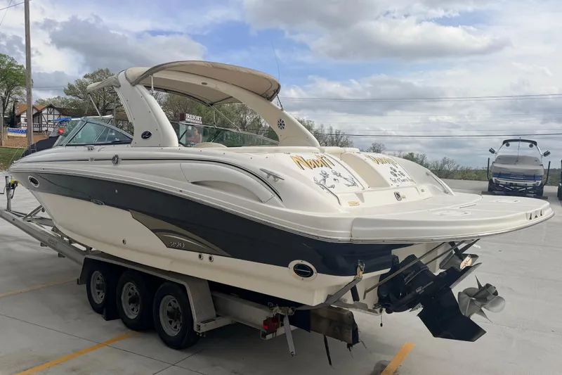 Slide: The Image of 2002 Sea Ray 290 Bowrider on trailer, parked outdoors under cloudy sky. - 3
