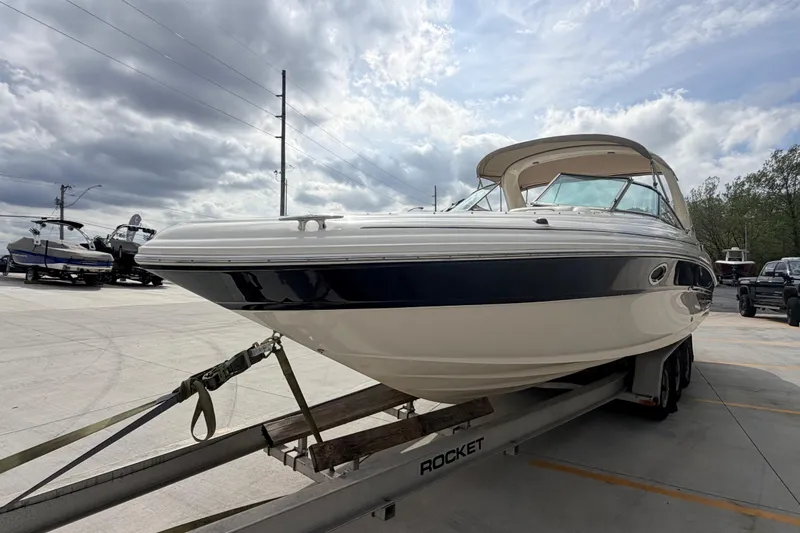 Slide: The Image of 2002 Sea Ray 290 Bowrider on trailer under cloudy sky in parking lot. - 5