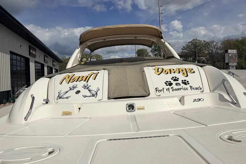 Slide: The Image of 2002 Sea Ray 290 Bowrider boat with custom "Nauti Dawgs" graphics at Sunrise Beach. - 8