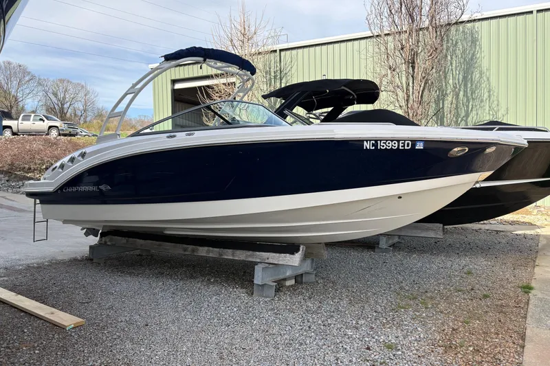 The Image of 2016 Chaparral 246 SSi boat on display, blue and white hull, parked outdoors. - 0