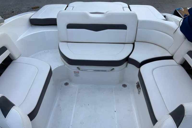 Slide: The Image of 2016 Chaparral 246 SSi boat interior with white cushioned seating arrangement. - 2