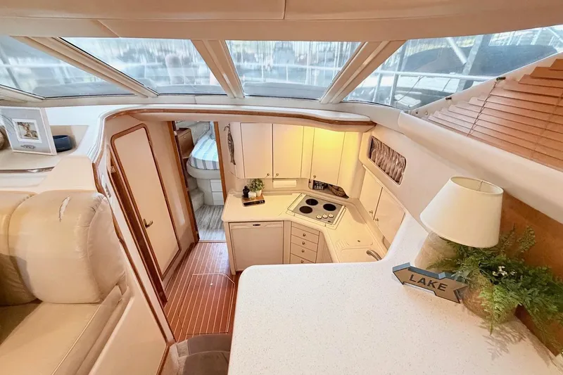 Slide: The Image of Interior of 1997 Sea Ray 420 Aft Cabin yacht, featuring kitchen and cozy seating area. - 11