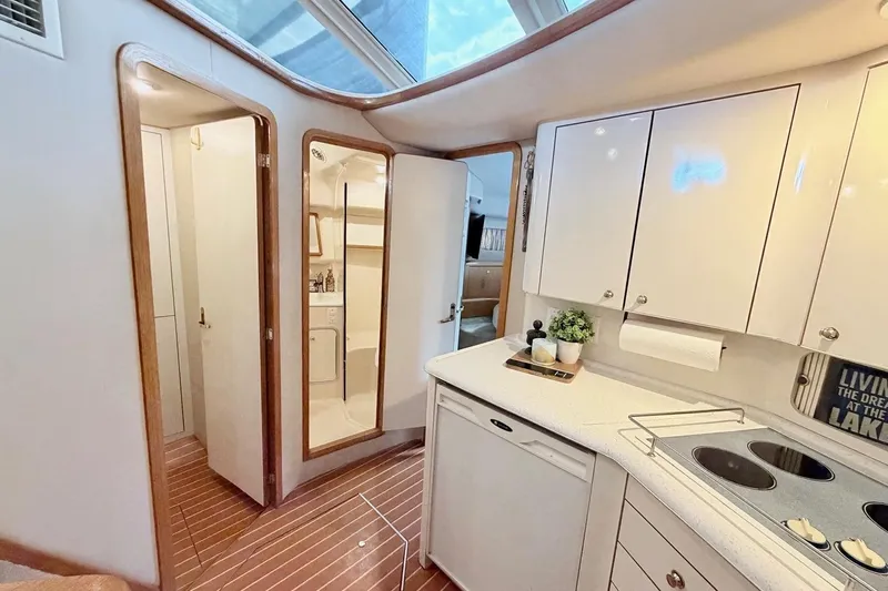 Slide: The Image of Interior of 1997 Sea Ray 420 Aft Cabin yacht with modern kitchen and wooden flooring. - 16
