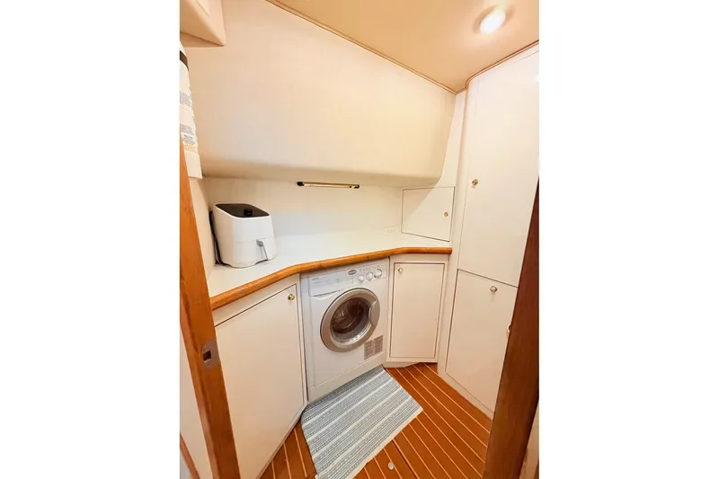 Slide: The Image of Laundry area in 1997 Sea Ray 420 Aft Cabin yacht with washer and storage cabinets. - 27