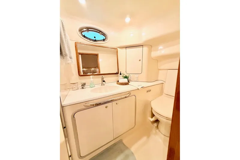 Slide: The Image of Luxurious bathroom in 1997 Sea Ray 420 Aft Cabin yacht, featuring elegant fixtures and ample storage. - 28