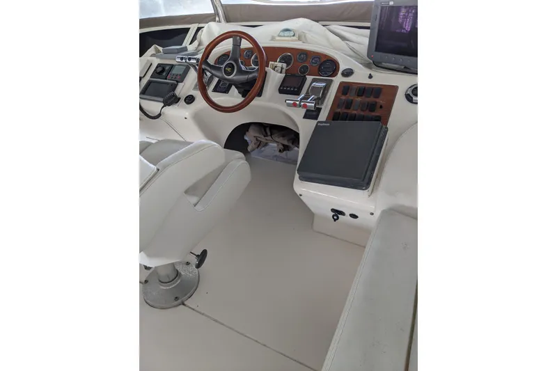 Slide: The Image of 1996 Sea Ray 420 Aft Cabin helm with steering wheel and control panel. - 30