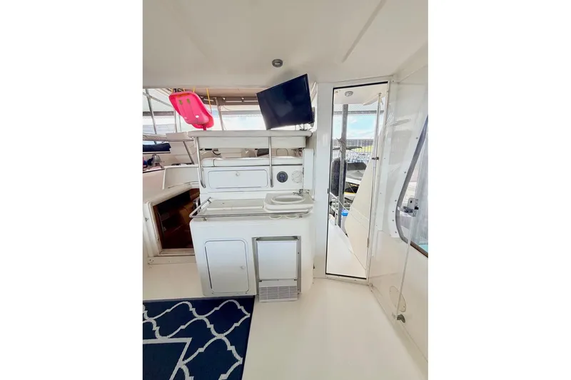 Slide: The Image of 1997 Sea Ray 420 Aft Cabin interior with kitchenette, TV, and nautical decor. - 4