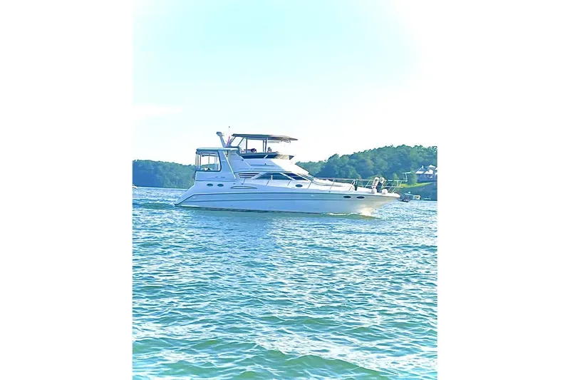 Slide: The Image of 1997 Sea Ray 420 Aft Cabin yacht docked in a marina under a covered structure. - 40