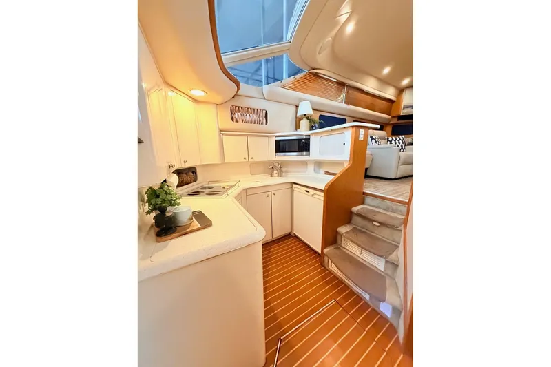 Slide: The Image of Interior of 1997 Sea Ray 420 Aft Cabin yacht with modern kitchen and wooden flooring. - 5