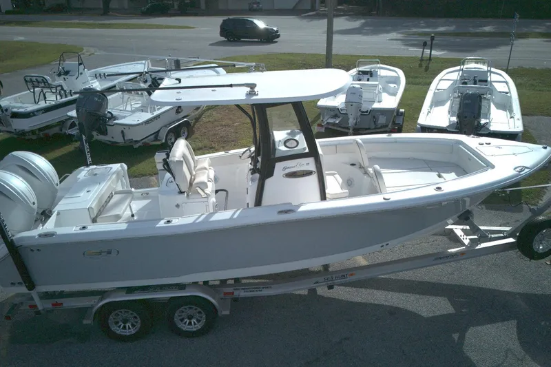 The Image of 2024 Sea Hunt Gamefish 25 boat on trailer, surrounded by other boats. - 1