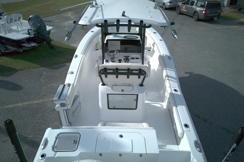 Slide: The Image of 2024 Sea Hunt Gamefish 25 boat interior with console and seating, parked outdoors. - 10