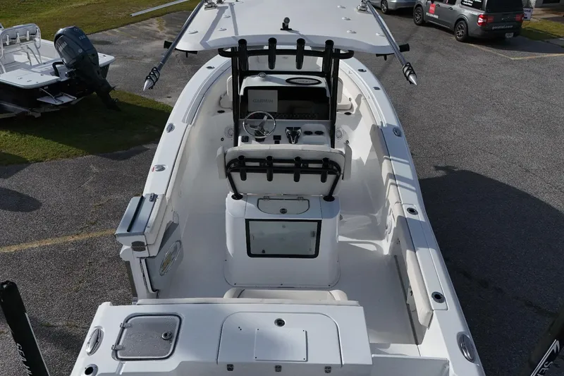 Slide: The Image of 2024 Sea Hunt Gamefish 25 boat interior with console and seating, parked on pavement. - 9