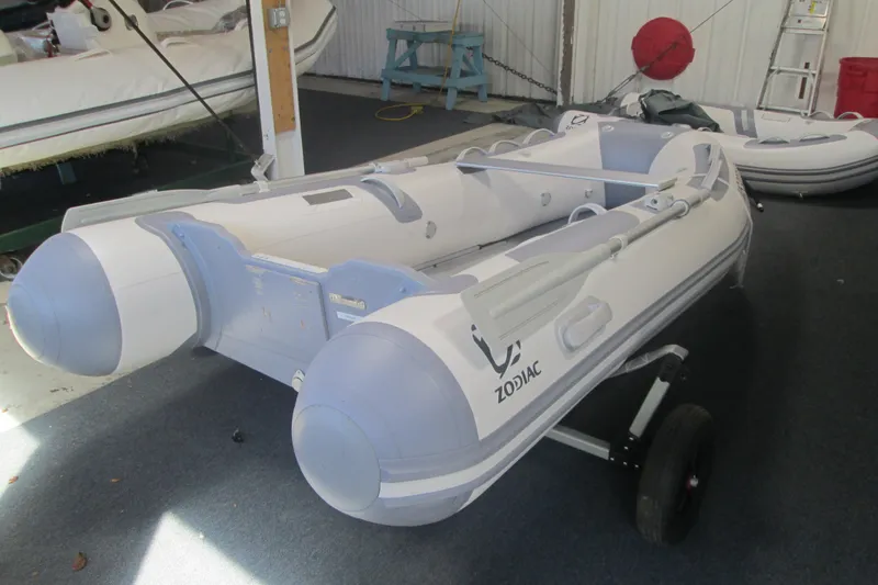 The Image of 2023 Zodiac Cadet 310 Alu inflatable boat in showroom, featuring durable design and oars. - 0