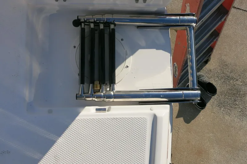 Slide: The Image of 2026 Robalo R202 Explorer boat ladder, folded on deck, with textured surface. - 23