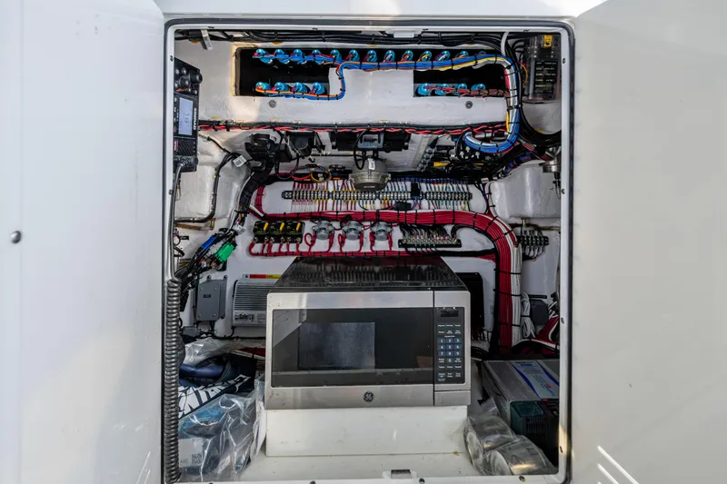 Slide: The Image of Electrical compartment of 2024 Contender 44 ST boat with wiring and microwave. - 19