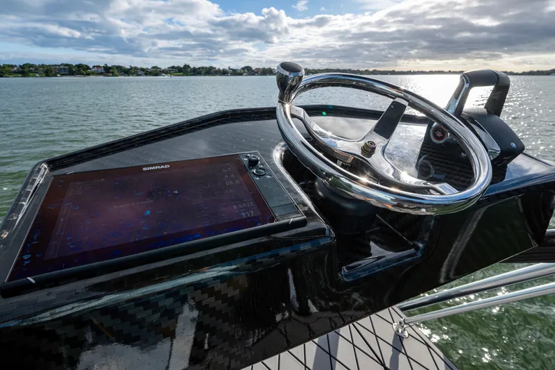 Slide: The Image of 2024 Contender 44 ST boat helm with Simrad display on calm water. - 23