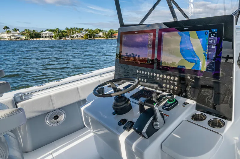 Slide: The Image of 2024 Contender 44 ST boat dashboard with navigation screens and steering wheel. - 6