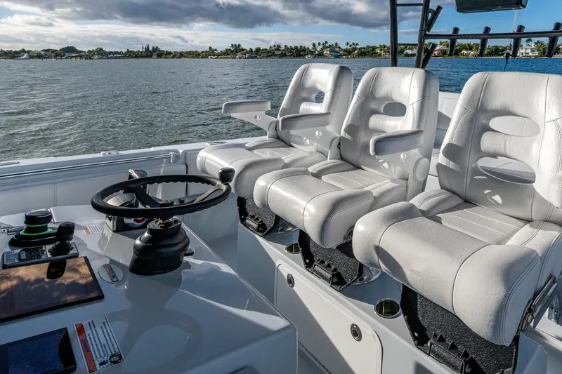 Slide: The Image of 2024 Contender 44 ST boat cockpit with white leather seats and steering wheel. - 9