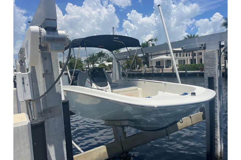 The Image of 2022 Boston Whaler 16 SS boat on lift, under blue sky with clouds. - 5