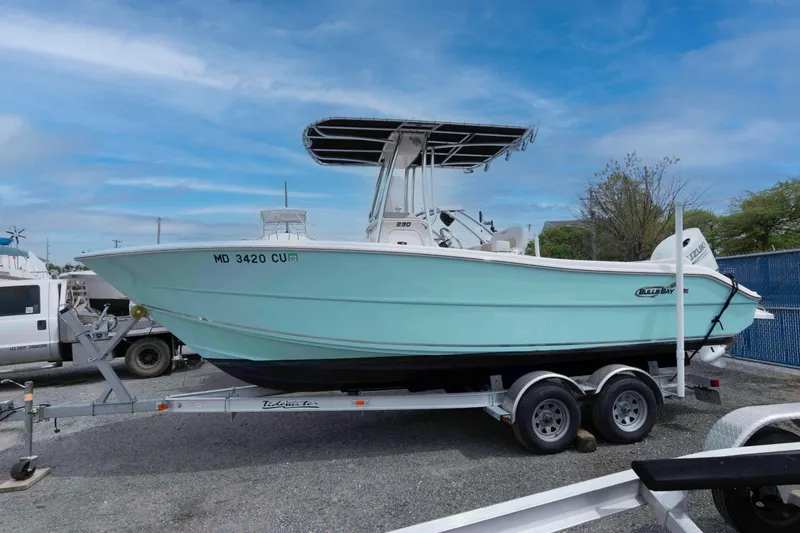 The Image of 2023 Bulls Bay 230 Center Console boat on trailer, parked outdoors under blue sky. - 0
