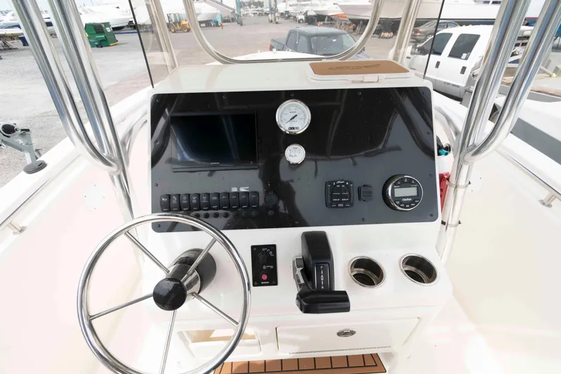 Slide: The Image of 2023 Bulls Bay 230 Center Console boat dashboard with steering wheel and controls. - 7