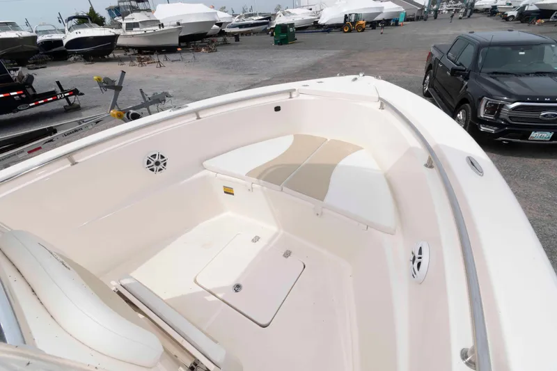 Slide: The Image of 2023 Bulls Bay 230 Center Console boat interior at a marina with parked vehicles. - 8