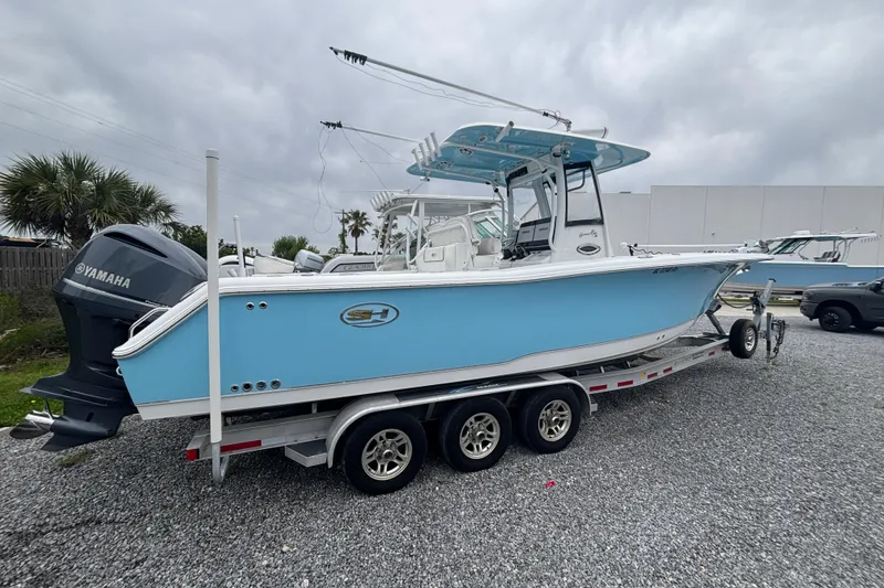 The Image of 2017 Sea Hunt Gamefish 30 boat on trailer with Yamaha engine, parked outdoors. - 1