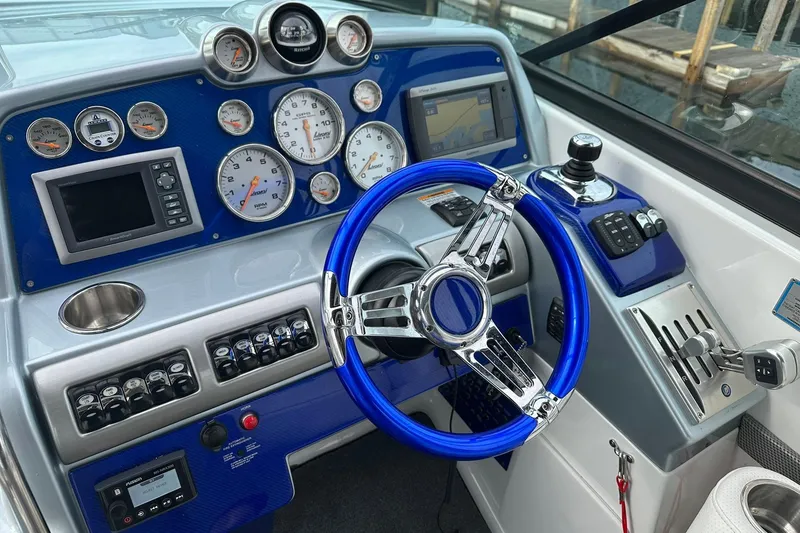Slide: The Image of Control panel of a 2012 Formula 350 FX6 boat with blue steering wheel and gauges. - 13