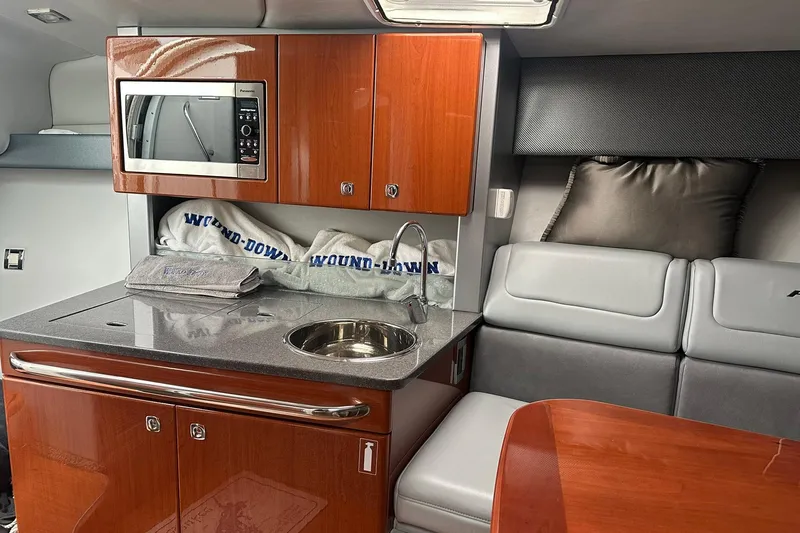 Slide: The Image of Interior of a 2012 Formula 350 FX6 boat with kitchenette and seating area. - 18