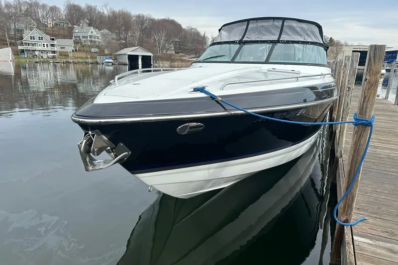 Slide: The Image of 2012 Formula 350 FX6 boat docked on calm water, surrounded by lakeside houses. - 2