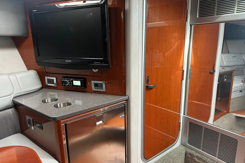 Slide: The Image of Interior of a 2012 Formula 350 FX6 boat with TV, fridge, and seating area. - 20