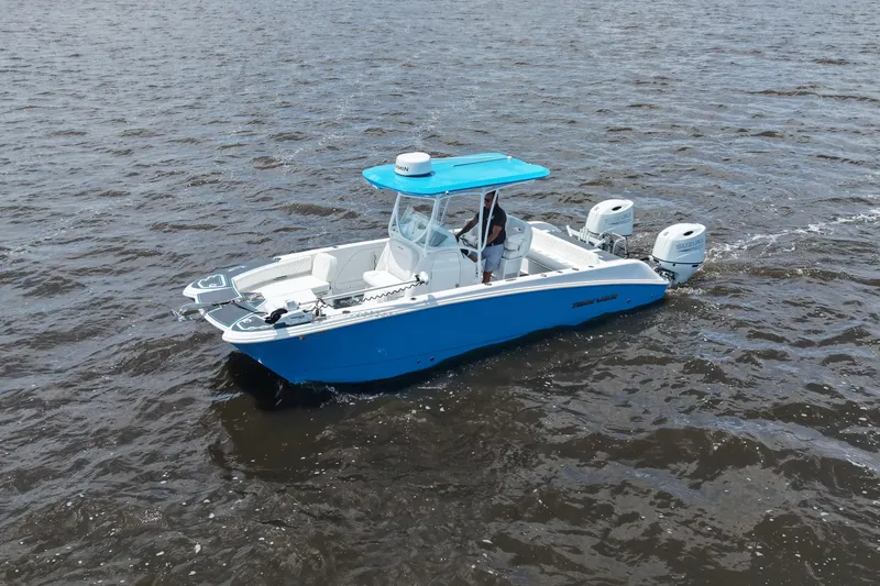 Slide: The Image of 2024 Twin Vee 240 GFX CC boat cruising on open water, featuring dual engines. - 10