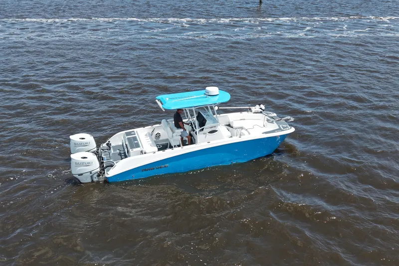 Slide: The Image of 2024 Twin Vee 240 GFX CC boat with dual Suzuki engines on open water. - 12