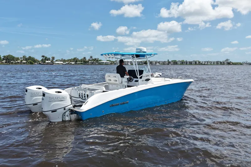 Slide: The Image of 2024 Twin Vee 240 GFX CC boat on water with dual Suzuki engines. - 13