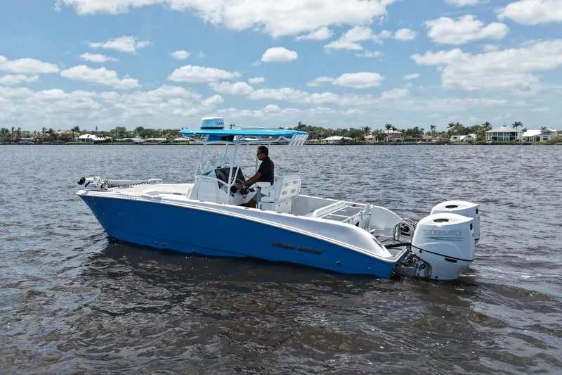 Slide: The Image of 2024 Twin Vee 240 GFX CC boat cruising on a sunny day with dual Suzuki engines. - 14