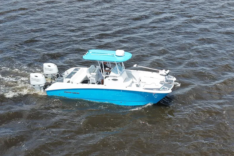 Slide: The Image of 2024 Twin Vee 240 GFX CC boat cruising on open water with dual Suzuki engines. - 16