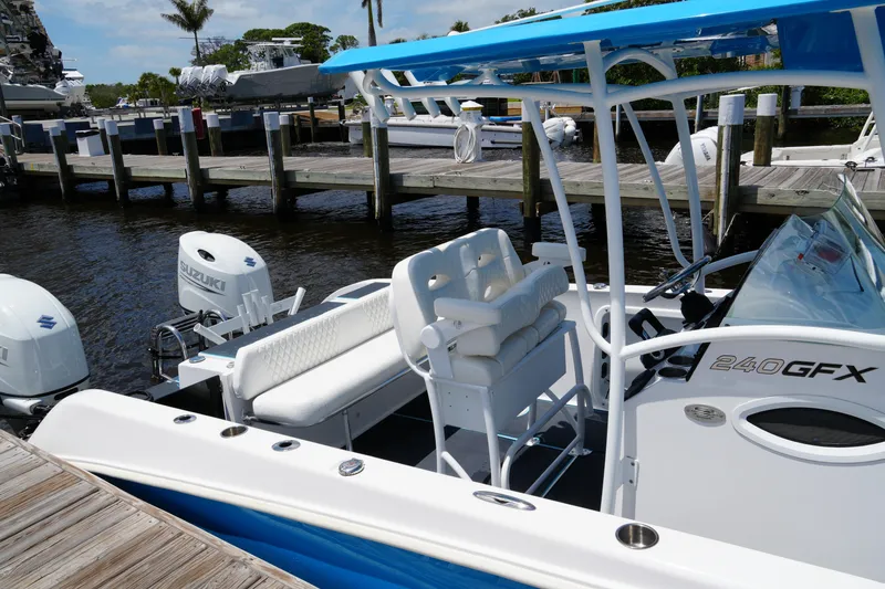Slide: The Image of 2024 Twin Vee 240 GFX CC boat docked, featuring Suzuki engines and sleek design. - 21