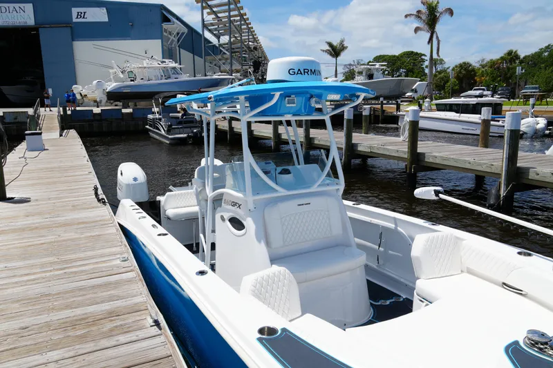 Slide: The Image of 2024 Twin Vee 240 GFX CC boat docked at a marina with clear skies. - 23