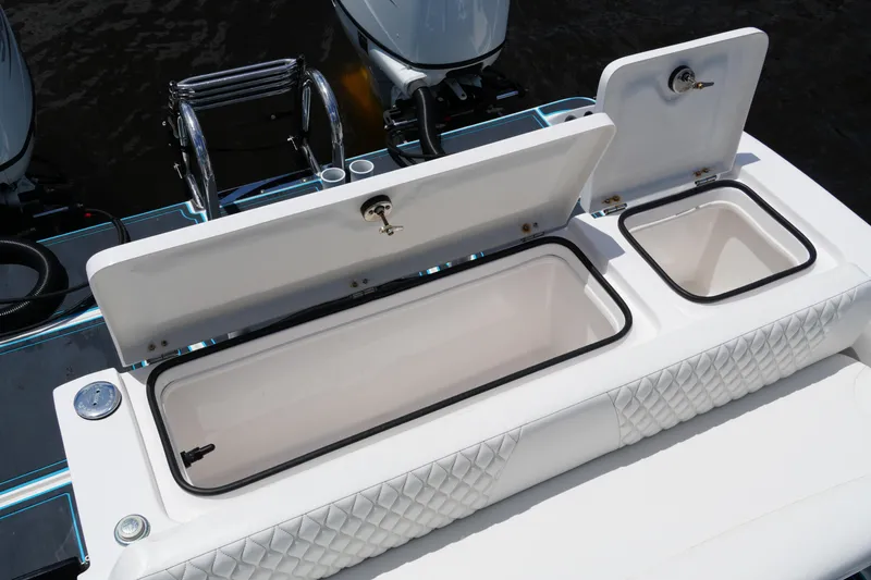 Slide: The Image of 2024 Twin Vee 240 GFX CC boat with open storage compartments and dual engines. - 28