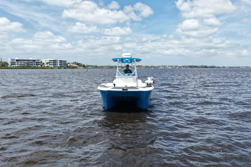 Slide: The Image of 2024 Twin Vee 240 GFX CC boat on open water under a partly cloudy sky. - 3
