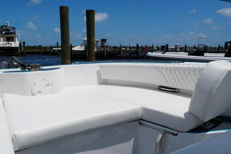 Slide: The Image of 2024 Twin Vee 240 GFX CC boat with white cushioned seating at a marina. - 32