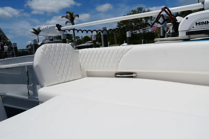 Slide: The Image of 2024 Twin Vee 240 GFX CC boat with white quilted seating, docked under blue sky. - 34